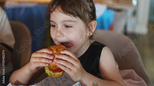 Girl enjoys a tasty burger in a cozy setting