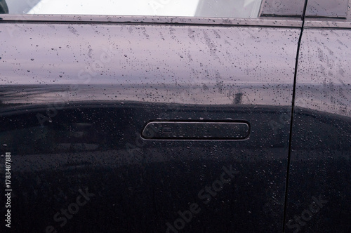 Konstfotografi A retractable door handle for a modern black car door.