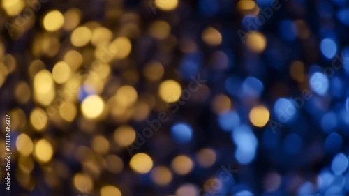 Abstract blurred bokeh background with warm gold and cool blue colors perfect for festive holiday
