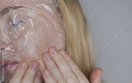 Microplastics in cosmetics. A woman applied a care cream to her skin, now it is covered with plastic particles and microbeads. Cosmetics toxicity concept