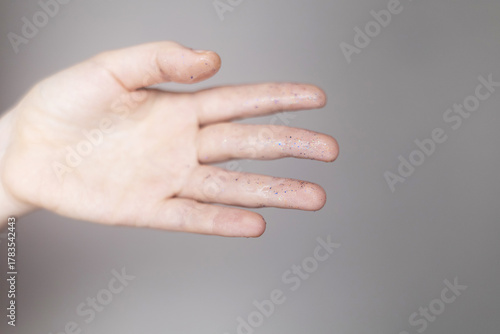 Microplastics in cosmetics. A woman applied a care cream to her skin, now it is covered with plastic particles and microbeads. Cosmetics toxicity concept