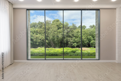 Floor-to-ceiling window with garden view in empty spacious room. Interior design