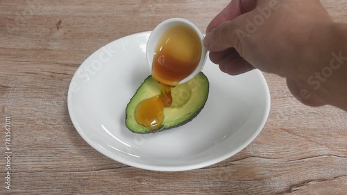 fresh ripe avocado half cutting arranging on plate dressing honey from cooking pan