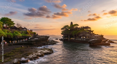 Fototapeta Naklejka Na Ścianę i Meble -  A serene Balinese temple by the sea during sunset with golden tropical light and wide sky copy space, ideal for travel or cultural visuals.