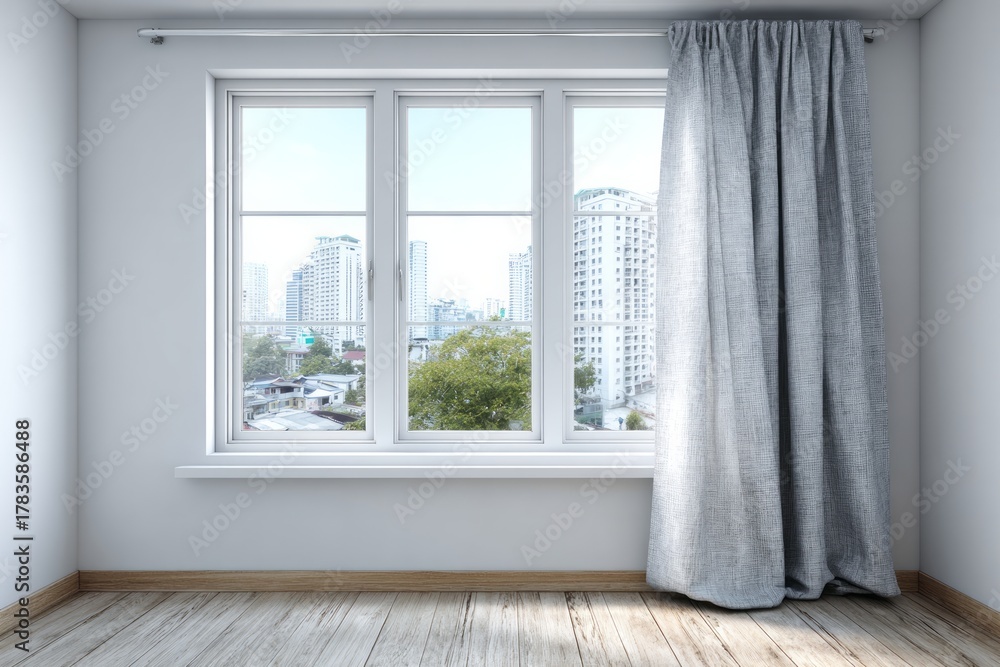 Fototapeta premium Interior room corner featuring a large window with sheer drapery overlooking an urban landscape.
