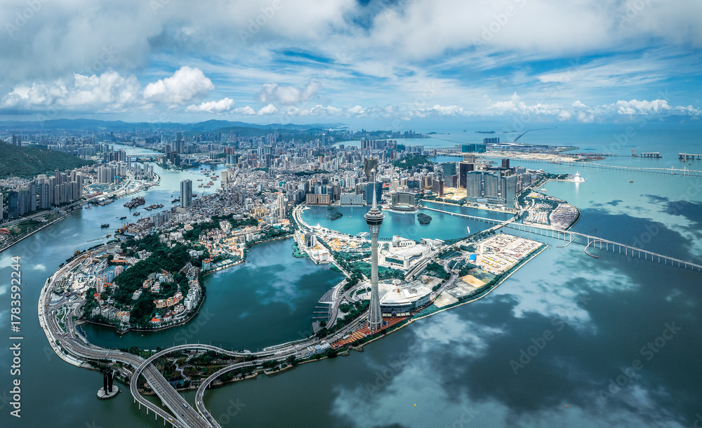 Obraz premium Panoramic aerial view of the entire city peninsula with a landmark tower and bridges on a sunny day in Macau.
