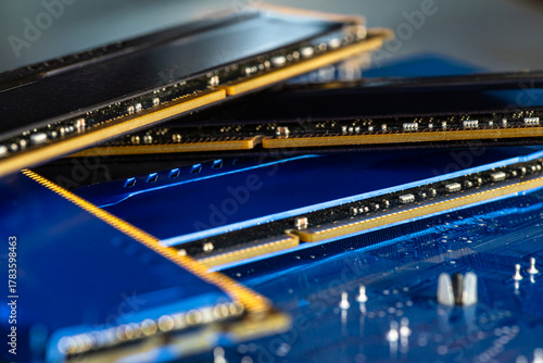 Tableau sur toile Four DDR memory chips in different colors lying on a blue printed circuit board