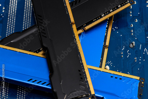 Four DDR memory chips in different colors lying on a blue printed circuit board.