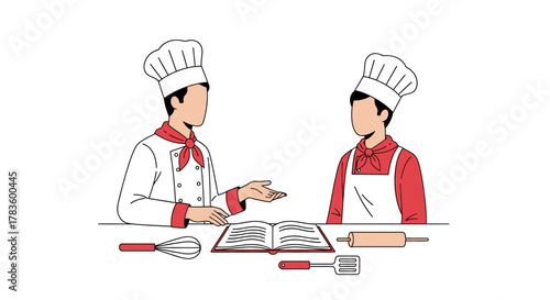 Two chefs in uniform, one experienced and one apprentice, are discussing a recipe book with baking tools on the table.