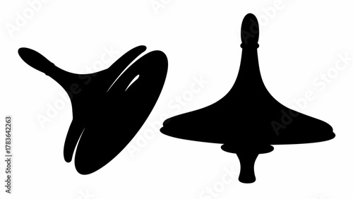 Two black spinning tops one tilted and one upright on a white background are displayed here