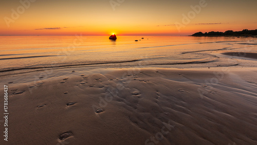 Fototapeta Naklejka Na Ścianę i Meble -  Sunset seascape with rock on sandy beach in Lahemaa National Park, Estonia.