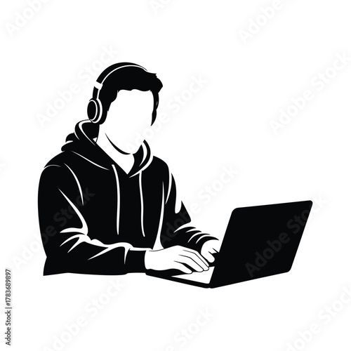 Silhouette of a person wearing headphones using a laptop computer