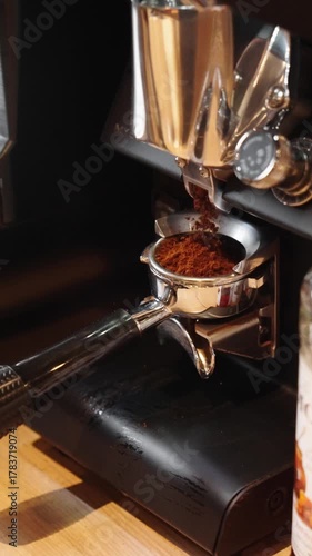 ground coffee is poured into a coffee machine to make fresh coffee in a coffee shop or restaurant in slow motion vertical video