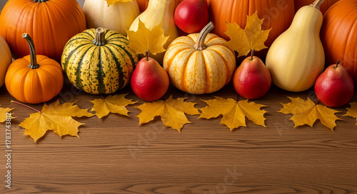 Image of autumn harvest: pumpkins, gourd, pear, and maple leaf on wooden surface, representing abundance, autumn season, and thanksgiving concept