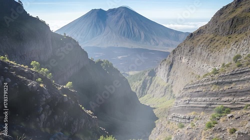 Majestic Mountain Valley Landscape with Layers of Rock and Distant Volcano Under Clear Sky seemless looping quality video 4K