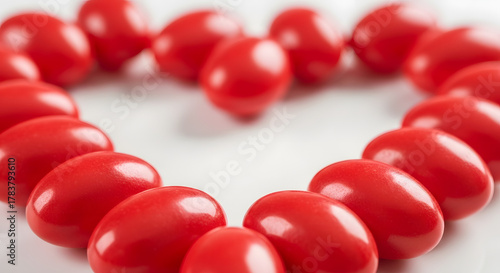 Red Cherry Tomatoes Arranged in a Heart Shape on a White Surface