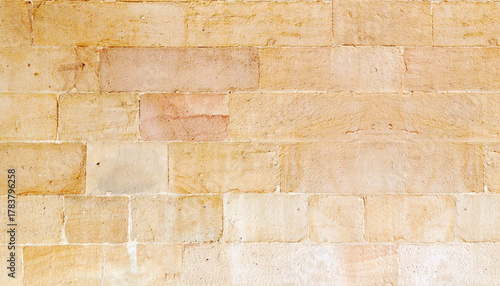 Close-up of a weathered, textured sandstone brick wall, showcasing natural patterns and hues