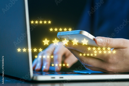 Person using a smartphone while typing on a laptop with glowing star ratings in the background