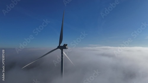 Une éolienne émerge au dessus d'un banc de brouillard, au mois de novembre, en automne, sur un beau ciel bleu. Parc éolien de Doncourt-les-Longuyon, en Meurthe et Moselle, Lorraine.
