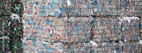 Compressed blocks of recycled plastic waste in large stacks on garbage recycling plant