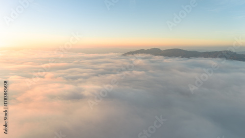 Aerial drone shot of fog blanket glowing in the warm evening sun over calm Bavarian countryside