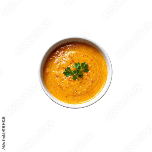  A bowl of soup garnished with fresh herbs on a white background.  pumpkin soup topped with fresh coriander.