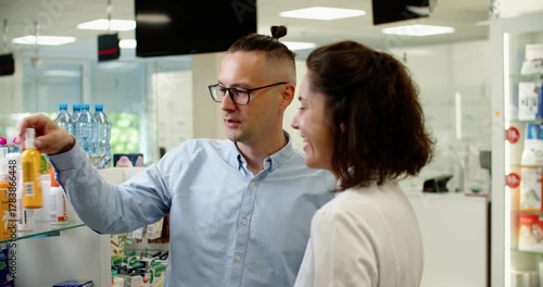 pharmacist carefully reviews medication labels with customer, bright pharmacy environment where knowledgeable pharmacist provides clear medication instructions