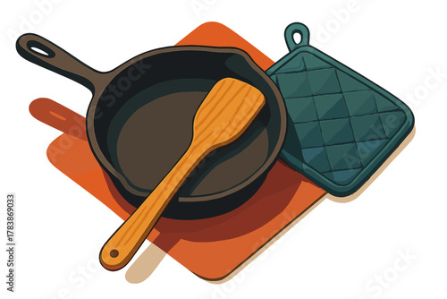 Cast iron skillet with wooden spatula and quilted pot holder on an orange kitchen mat