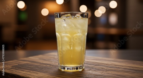 Glass of Iced Lemonade on a Wooden Table with Blurred Background Lights