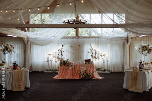 Wallpaper Mural Beautiful wedding reception setup with white flowers, green accents, round tables, and soft lighting in a wooden hall with draped fabric ceiling. Concept: celebration, romance, event design, luxury. Torontodigital.ca
