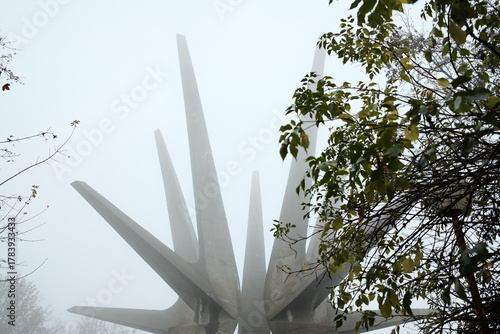 View of the Kosmaj Monument framed by autumn foliage and soft fog, creating a serene and mystical mood