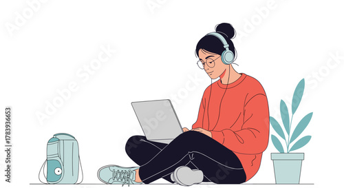 Young woman with glasses and headphones sitting on the floor, focused on her laptop, with a speaker and a potted plant nearby in a cozy setting.