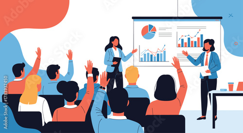 Business training session with presenters showing charts on a screen to an engaged audience, who are raising their hands to ask questions.