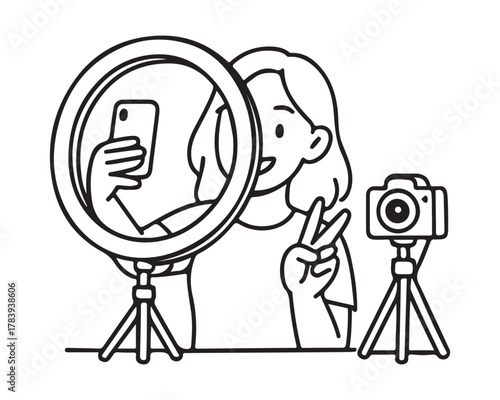 Girl making a peace sign while taking a selfie with her phone in front of a ring light and camera setup for her vibrant social media channel