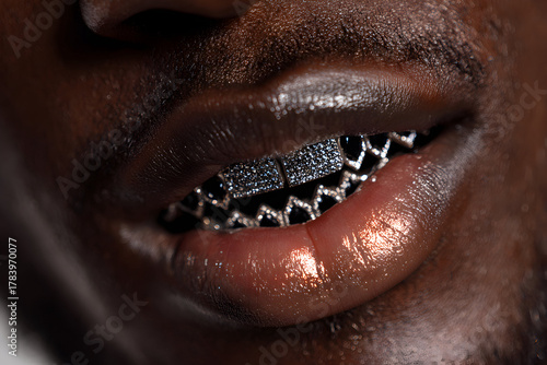 Close-up of a black mans glossy lips with diamond grillz teeth jewelry