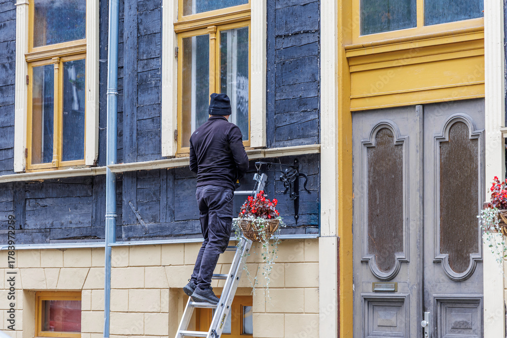 Fototapeta premium Worker on Ladder Installing Decoration