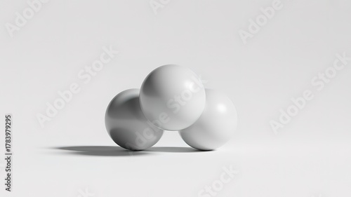 Three White Spheres Stacked in a Triangular Formation on a White Surface ball round