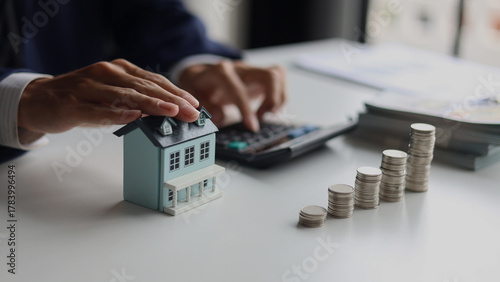 Investing in Real Estate, Real estate agent or investor calculating, planning, analyzing financial data for property investment. Themes of saving, investing, financial aspects of purchasing a home.