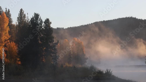 Fog Lifting at Dawnon the Snake River  in Autumn in Grand Teton National Park Wyoming