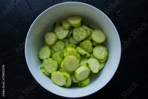 A white plate filled with sliced cucumber