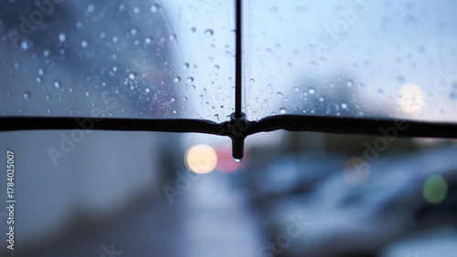 Foto A transparent umbrella and a street out of focus, an autumn city in cloudy weath
