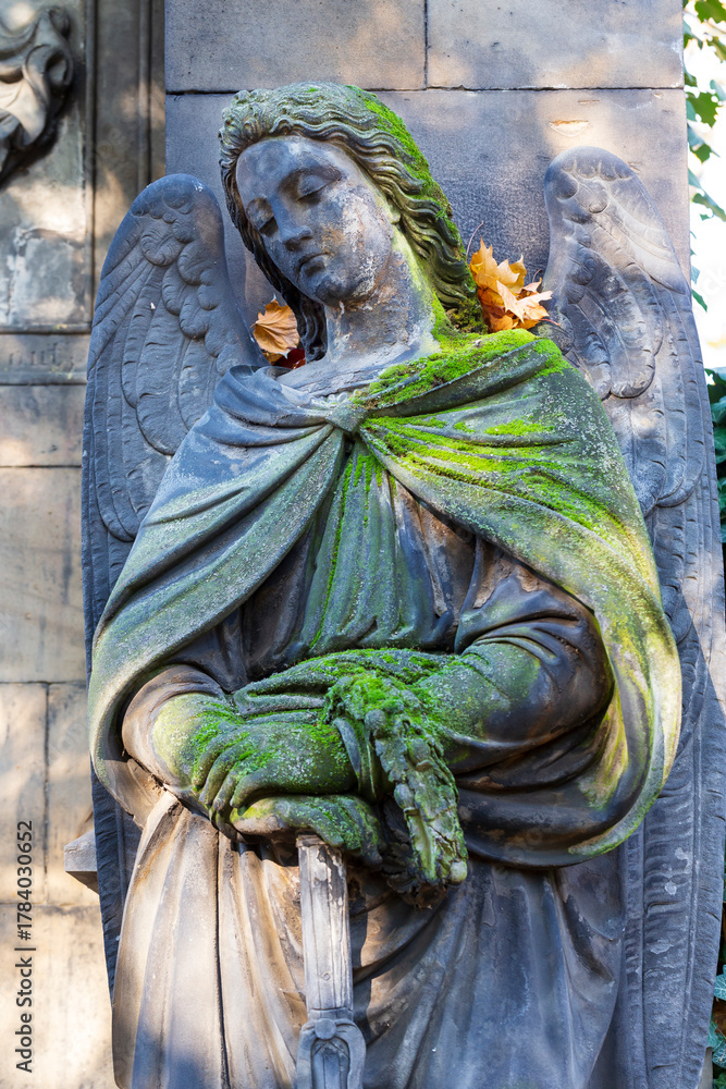 Naklejka premium Historic Statue on the autumn mystery old Prague Cemetery, Czech Republic