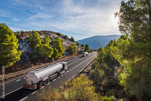Two fuel tanker trucks passing each other on a two-way mountain road
