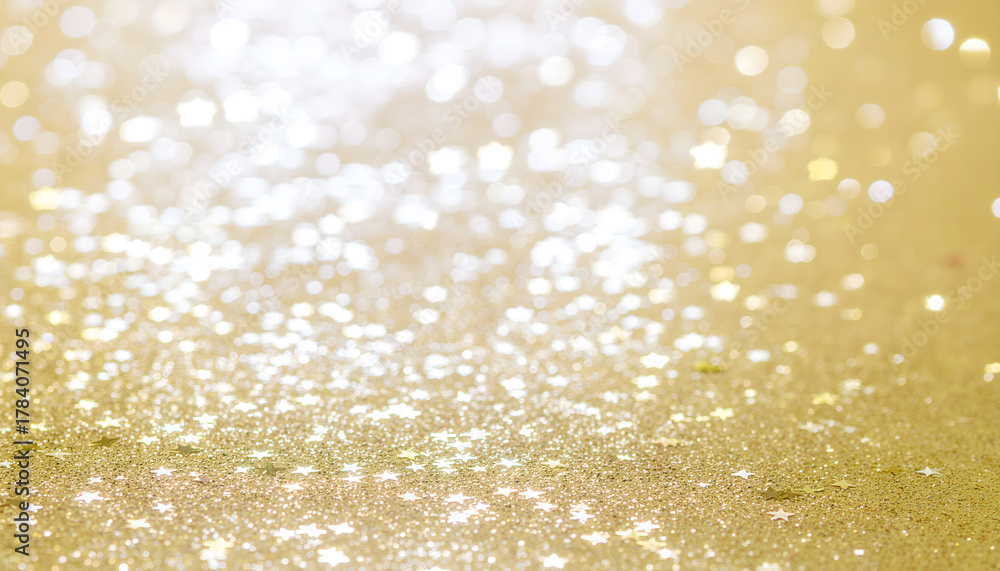 Fototapeta premium A vibrant, celebratory image featuring an abundance of golden stars and sparkling glitter against a bright, warm white and gold background.