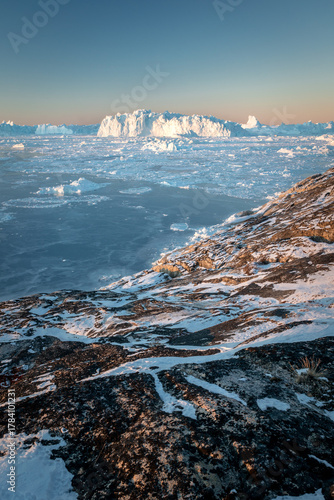 Giant icebergs floating in Ilulisat icefjord, Greenland. Massive icebergs, calved from the Sermeq Kujalleq Glacier, float through the Ilulissat Icefjord in western Greenland