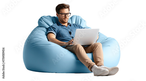 Man working on laptop in beanbag chair: A focused man with glasses engrossed in his laptop sits comfortably in a plush beanbag chair, presenting an image of relaxed productivity and modern living.
