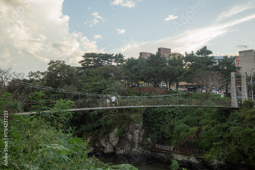 people standing on suspension bridge in the evening in jeju island
