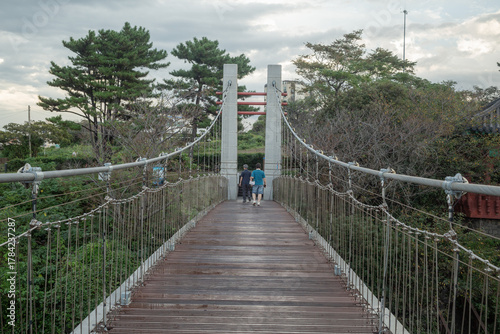 people crossing on suspension bridge in jeju island