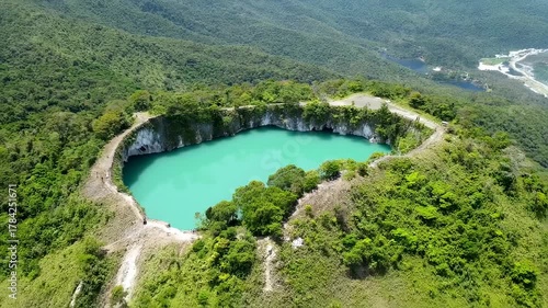 Wallpaper Mural Aerial view of a crater lake with bright turquoise water, surrounded by lush green terrain Torontodigital.ca