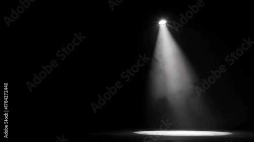 Single Spotlight Illuminating a Dark Stage with Wisps of Smoke Creating an Ethereal Atmosphere